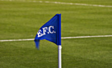 Everton Corner Flag which is a Royal Blue triangle on a white pole with the letters EFC on it blowing in the wind to signify the winds of change blowing through Goodison Park